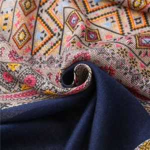Vue détaillée d'une écharpe en coton et lin à motifs losanges et bordure bleue