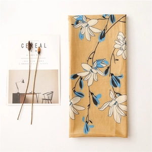 Detail of floral chiffon scarf in ginger yellow with white and blue magnolia print