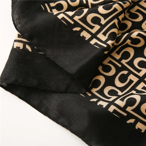 Detailed macro shot of cotton linen scarf texture featuring classic black and gold patterns