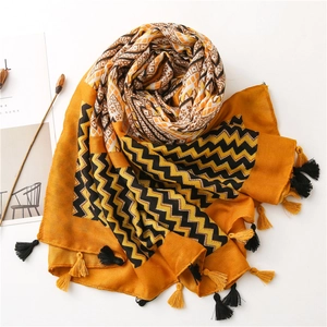 Detail of bohemian cotton linen scarf with ginger yellow ripples and fringe tassels