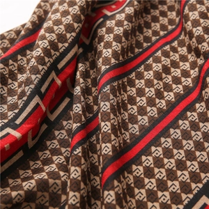 Macro shot of knit fabric texture featuring vintage plaid and red striped detail