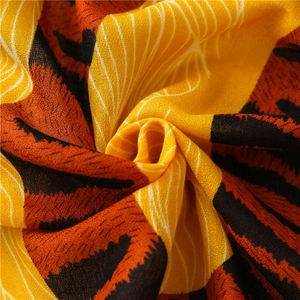 Détail macro du tissu d'écharpe léopard montrant le tissage doux et la texture orange