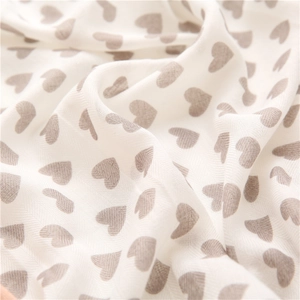 Detailed macro view of white herringbone weave fabric with grey heart patterns