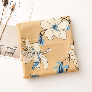 Detailed macro view of ginger yellow floral scarf with elegant white magnolia pattern