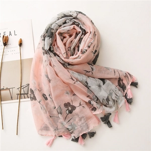Detailed macro view of soft pink floral scarf with elegant long fringe tassels