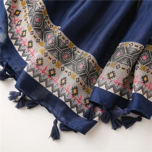 Détail d'une écharpe en coton et lin bleu foncé avec broderies et franges