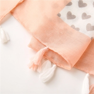 Close-up of peach cotton linen scarf showing herringbone weave and heart patterns