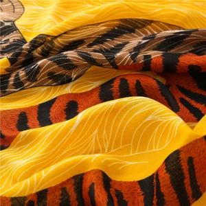 Gros plan d'un foulard léger imprimé léopard jaune montrant la texture du tissu