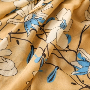 Detailed macro view of mustard yellow floral fabric with soft blue and white petal patterns