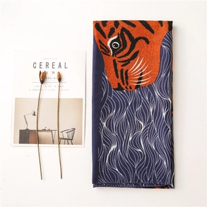 Détail de l'imprimé tigre orange vif sur une écharpe légère bleu marine pour femme