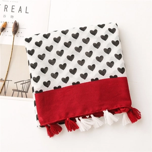 Detail of cotton linen scarf featuring heart pattern, jacquard red border and tassels
