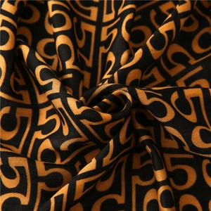 Detailed macro shot of cotton linen scarf texture with black and orange geometric patterns