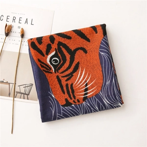 Vue détaillée du foulard en soie plié avec imprimé tigre orange et texture lisse