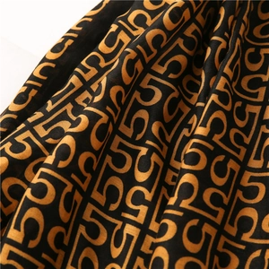 Close-up of lightweight cotton-linen scarf fabric with orange and black number patterns