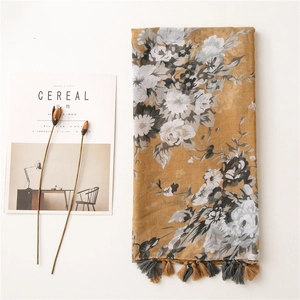 Detail of floral printed scarf with fringe tassels on a minimalist table setting