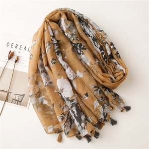 Detail of floral pattern on ginger yellow cotton scarf with soft fringe edges