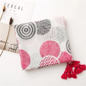 Close-up of white floral cotton scarf with red tassels and geometric patterns