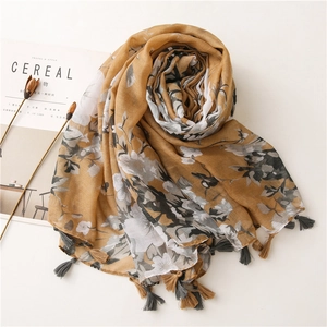 Detailed texture of ginger yellow floral scarf featuring delicate fringe and soft fabric
