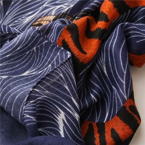 Gros plan d'imprimé léopard et motifs blancs sur tissu d'écharpe bleu en coton et lin
