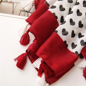 Detail of cotton linen scarf featuring heart prints and red-white fringe tassels