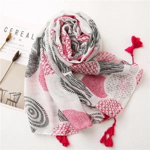 Detail of white floral cotton scarf with red tassels and modern printed patterns