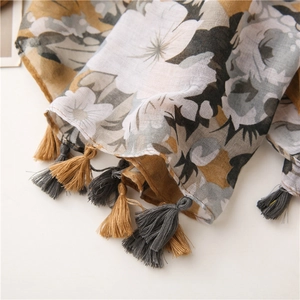 Close-up of abstract floral scarf with lightweight woven texture and bicolor fringe detail