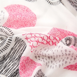 White floral cotton gauze scarf with tassels featuring pink and black geometric patterns