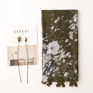 Detail of olive green floral scarf with soft fringe tassels and delicate flower prints