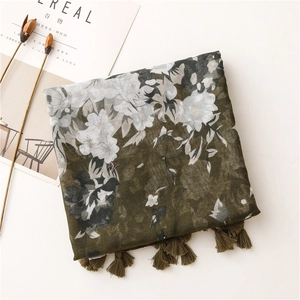 Detail of floral printed scarf in dark green with vintage patterns and elegant tassels