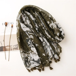 Detail of dark green floral shawl with soft tassels and intricate white flower print