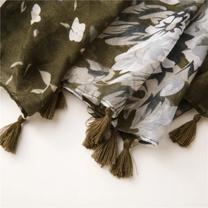 Close-up of floral print scarf with olive green tassels and lightweight cotton-linen fabric