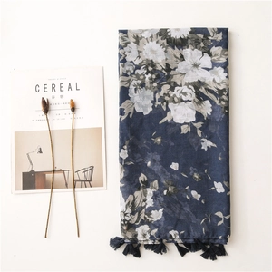 Detail of navy blue floral scarf with elegant fringes and light cotton texture