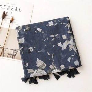 Close-up of navy floral scarf showing white flower print and soft fringe tassels