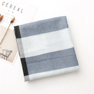 Détail d'une écharpe à carreaux bleus et blancs avec une texture tissée sur fond blanc