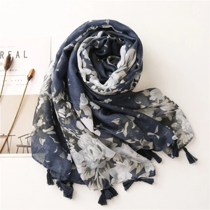 Detail of dark blue floral print scarf featuring elegant fringe edges and cotton texture