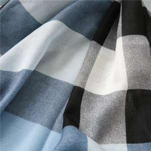 Gros plan sur la texture du tissu tissé à carreaux bleu, noir et blanc avec drapé