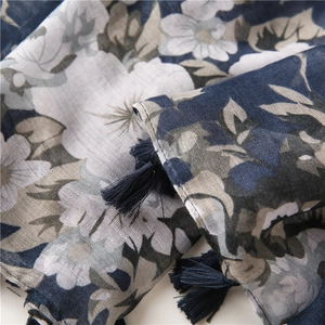 Close-up of floral print scarf with navy base and tassels showing fabric texture