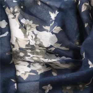 Macro view of blue floral print shawl fabric showing cotton linen texture and pattern