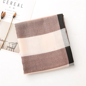 Détail de la texture du tissu de l'écharpe avec motif à carreaux marron et beige