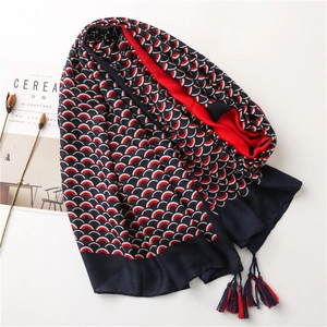 Dettaglio della sciarpa in cotone e lino con motivo a squame rosso e blu con nappe