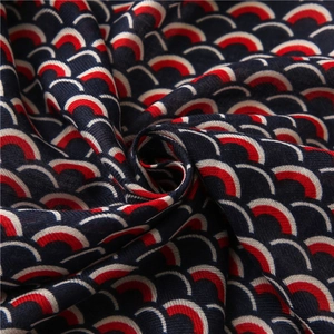 Dettaglio di sciarpa in cotone blu con motivi a scaglie colorate e consistenza intrecciata