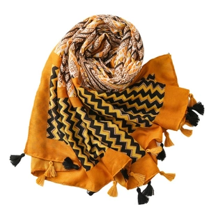 Ethnic yellow cotton scarf with black chevron patterns and fringe tassels on a white background