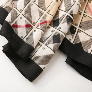 Detail of British style geometric scarf showing woven texture and gold dot pattern