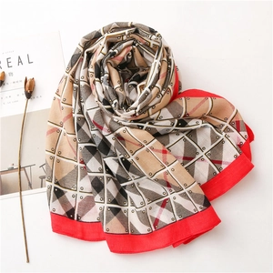 Detail of summer scarf showing khaki and red geometric patterns with cotton-linen feel