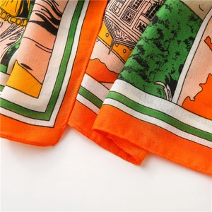 Detailed macro view of lightweight semi-transparent fabric with vibrant orange and green prints