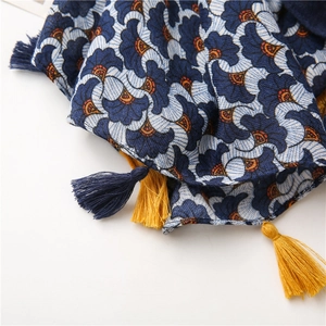 Close-up of floral print scarf with blue and ginger yellow tassels showing fabric texture