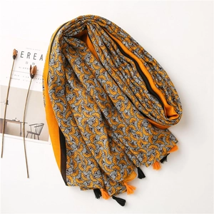 Detail of vintage floral pattern on ginger cotton scarf with decorative tassels
