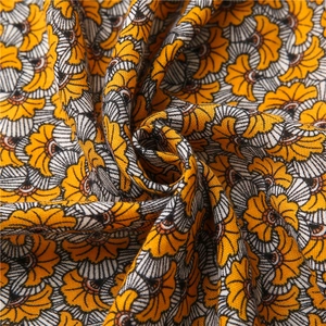 Macro shot of cotton linen scarf with vintage orange floral patterns and rich fabric texture