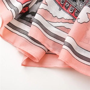 Close-up of lightweight fabric scarf showing detailed pink retro carriage prints and edges