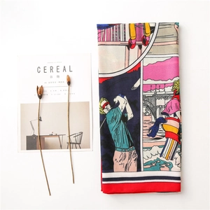 Flat lay of a printed scarf featuring golf scenes and magazine props on white background